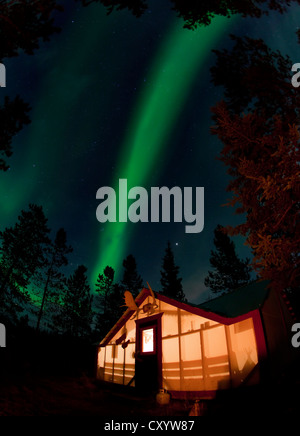 Allumé Allumé, wall tente, cabine avec lumières polaires du nord tourbillonnante, Aurora Borealis, vert, près de Whitehorse, Territoire du Yukon Banque D'Images