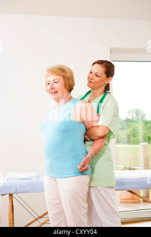 Femme traitée sur son épaule par un physiothérapeute Banque D'Images
