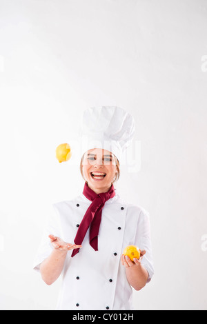 Jeune chef jonglant avec les citrons Banque D'Images