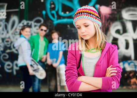 Les adolescents debout devant un mur de graffiti, une fille debout dans l'avant-plan Banque D'Images