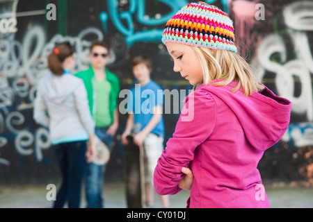 Les adolescents debout devant un mur de graffiti, une fille debout dans l'avant-plan Banque D'Images