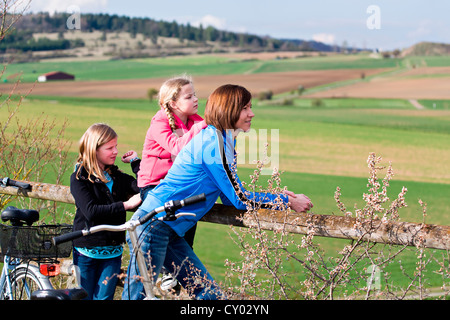 La mère et les deux filles avec des bicyclettes in rural landscape Banque D'Images