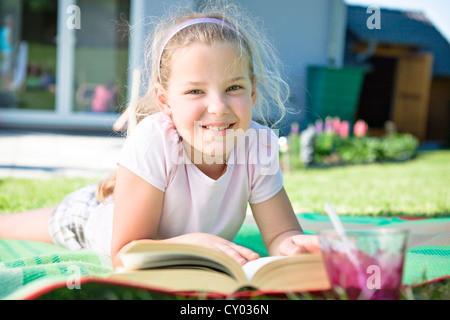 Fille avec un livre dans le jardin Banque D'Images