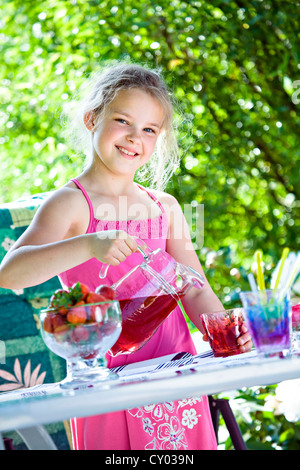 Fille debout à une table de jardin Banque D'Images