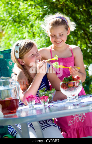 Deux sœurs, les filles, à une table de jardin Banque D'Images