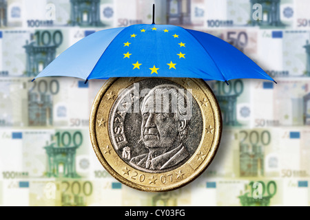 Une pièce d'un euro espagnole sous un parapluie de sauvetage de l'UE, l'image symbolique Banque D'Images