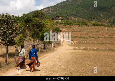 Deux femmes en costume national sur la façon de le chimi Lhakhang temple de la fertilité, Lobesa, Bhoutan, Asie du Sud Banque D'Images