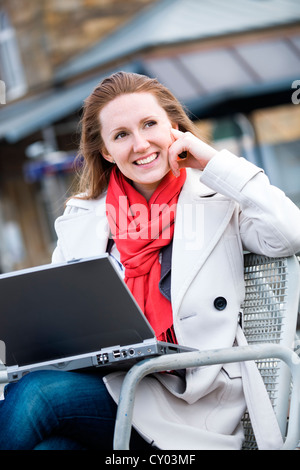 Young woman with laptop à rail station Banque D'Images