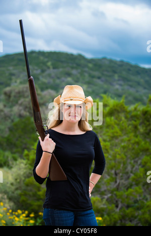 Femme avec chapeau de cowboy posant avec carabine fusil Banque D'Images