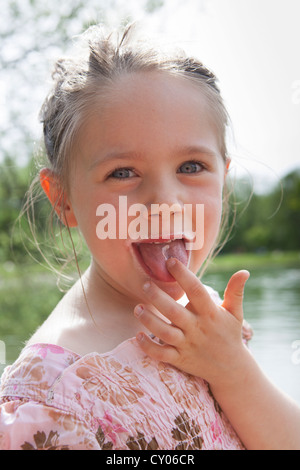 Petite fille, quatre ans, de lécher la crème glacée Banque D'Images