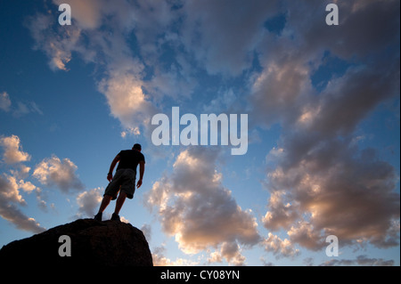 Silhouette de figure masculine debout sur rock Banque D'Images