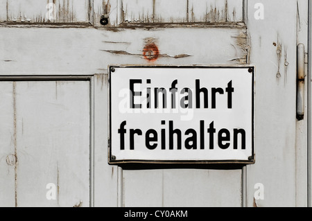 Lettrage signe 'Einfahrt freihalten', l'allemand pour l'entrée de 'garder' claire, sur une vieille porte en bois, PublicGround