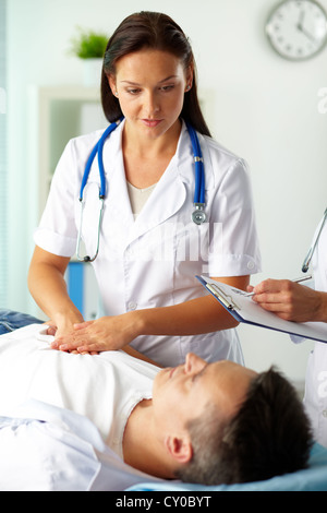 Portrait of female doctors pendant le traitement médical du patient in hospital Banque D'Images