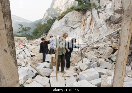 Les travailleurs de soulever des poids lourds rochers au San Huang Zhai monastère sur la montagne Song, Chine Banque D'Images