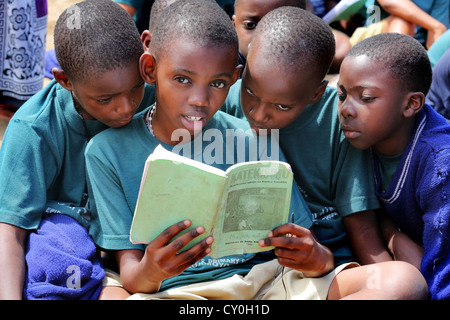 Les élèves au cours de l'enseignement religieux catholique lu dans un livre de catéchèse. Bagamoyo, Tanzanie Banque D'Images