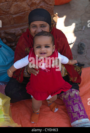 Un Bédouin Smiling Baby étant détenu par sa mère, Ibra, Oman Banque D'Images