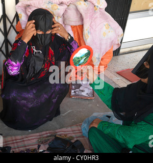 Bédouine à la recherche dans le miroir, Sinaw, Oman Banque D'Images