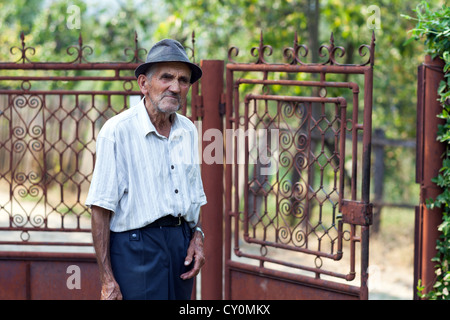 Portrait d'un vieil homme qui se tient près d'une barrière métallique à la campagne Banque D'Images