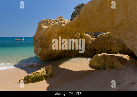 Le Portugal, l'Algarve, formations rocheuses, Praia da Marinha, Armacao de Pera bateau de pêche en distance Banque D'Images
