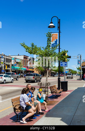 Famille assise sur un banc à Broadway (rue principale) dans la station balnéaire populaire de Wisconsin Dells, Wisconsin, États-Unis Banque D'Images