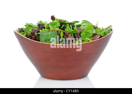 Un bol en bois plein d'un assortiment de légumes verts, y compris, les épinards, roquette, et romaine. Format horizontal sur un fond blanc. Banque D'Images