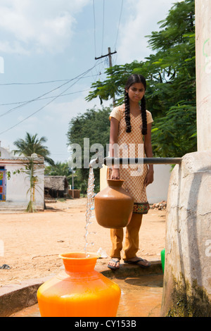 Fille village recueillir l'eau d'un réservoir d'eau communautaire. L'Andhra Pradesh, Inde Banque D'Images