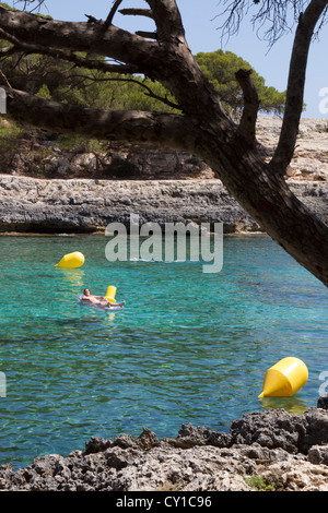 Femme de soleil sur matelas d'air flottant sur l'eau de mer Espagne Iles Baléares Majorque Mer Méditerranée Banque D'Images