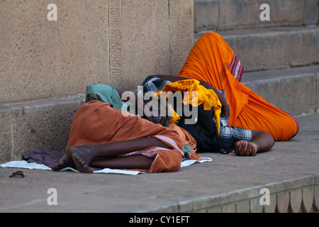 L'homme de dormir sur le trottoir des Ghats de Varanasi, Inde Banque D'Images