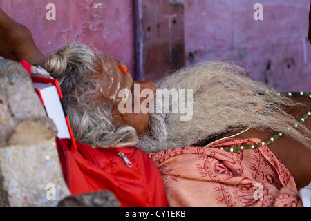 L'homme de dormir sur le trottoir des Ghats de Varanasi, Inde Banque D'Images