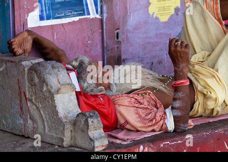 L'homme de dormir sur le trottoir des Ghats de Varanasi, Inde Banque D'Images