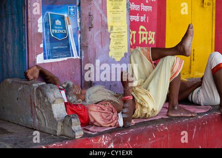 L'homme de dormir sur le trottoir des Ghats de Varanasi, Inde Banque D'Images