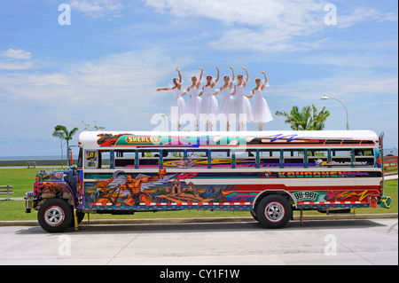 Une ballerine en équilibre sur le haut d'un diable rouge 'classique' bus. Banque D'Images