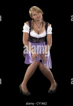 Blonde timide femme portant un costume traditionnel nommé dirndl en noir retour Banque D'Images