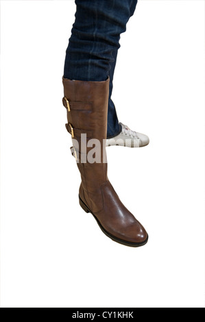 Une personne de sexe féminin d'essayer sur un isoltaed boot marron sur fond blanc Banque D'Images