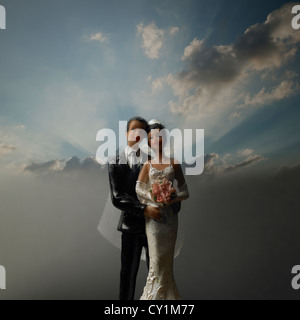 African American black époux et wedding cake topper avec la lumière du soleil traversant nuages de fond Banque D'Images