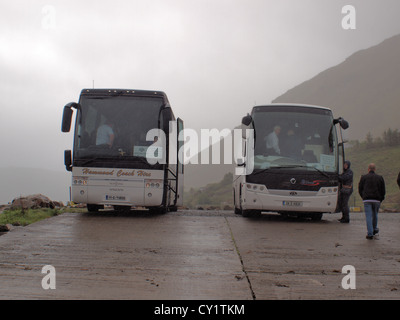 Tourisme deux autobus stationnés au Fjord de killary dans le Connemara, à l'entrée du service cataraman dans l'ouest de l'Irlande. Banque D'Images