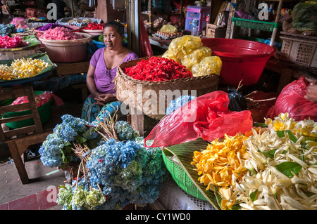 Femme vente de fleurs pour décorer des offrandes religieuses, au marché Pasar Badung à Denpasar, Bali, Indonésie Banque D'Images