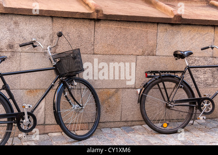 Deux vieux vélos classiques près du mur de pierre Banque D'Images