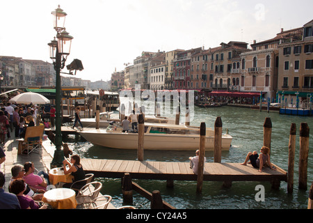 Vue sur le Grand Canal depuis le pont du Rialto, des gens assis dans un café et se détendre sur une jetée, San Marco, Venise, Italie Banque D'Images