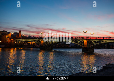 Crépuscule sur le pont Isabel II à Séville, Espagne avec feux de Pont se reflétant dans l'eau Banque D'Images