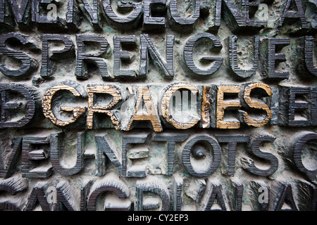 Modèle de lettres en relief en bronze recouvert de patine verte sur plaque murale, gracies a mis en évidence dans l'or dans sagrada famillia Banque D'Images