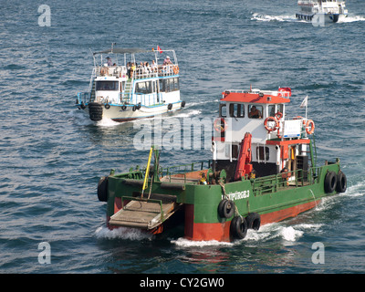 Le travail et le plaisir dans les eaux du Bosphore, bateau-ferry ou à l'arrière , bateau de travail puissant à l'avant Banque D'Images