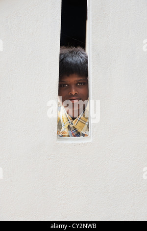 Village indien garçon à regarder à travers balustrade en béton. L'Andhra Pradesh, Inde Banque D'Images