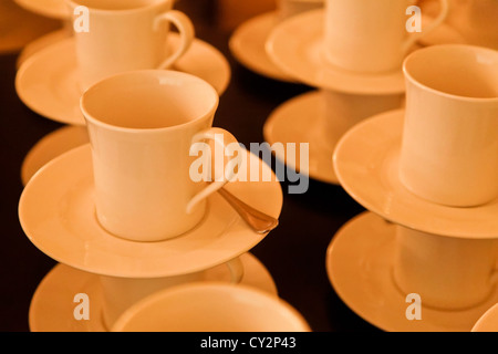 Affichage des tasses et soucoupes alignées avec des cuillères à café prêt à l'emploi. Banque D'Images