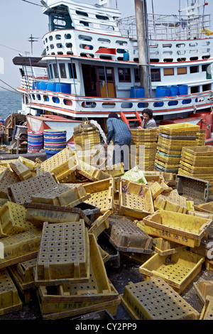 Déchargement de pêcheur thaïlandais les captures d'un chalutier de pêche commerciale. Port de pêche de Hua Hin Thaïlande S. E. Asie Banque D'Images