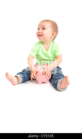 Smiling little boy with a pink piggy bank entre ses jambes, Banque D'Images