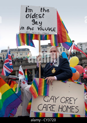 Un vieil homme gay dans un fauteuil roulant motorisé à Brighton Pride 2012. Banque D'Images