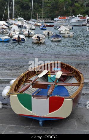 Bateau à rames avec drapeau italien dans le port de Portofino, Gênes, Italie du Nord. Banque D'Images