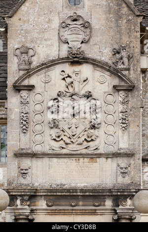 Une vue étroite de l'armoiries et inscription au dessus de l'entrée principale de la 17e siècle Maison d'école à Corsham, Wiltshire. Banque D'Images