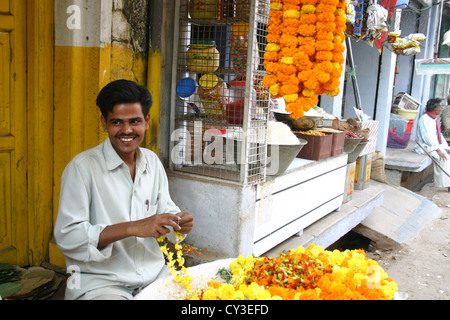 L'homme traditionnelle vente de fleurs jaune ixora à New Delhi pour le festival hindou de Durga Puja Banque D'Images